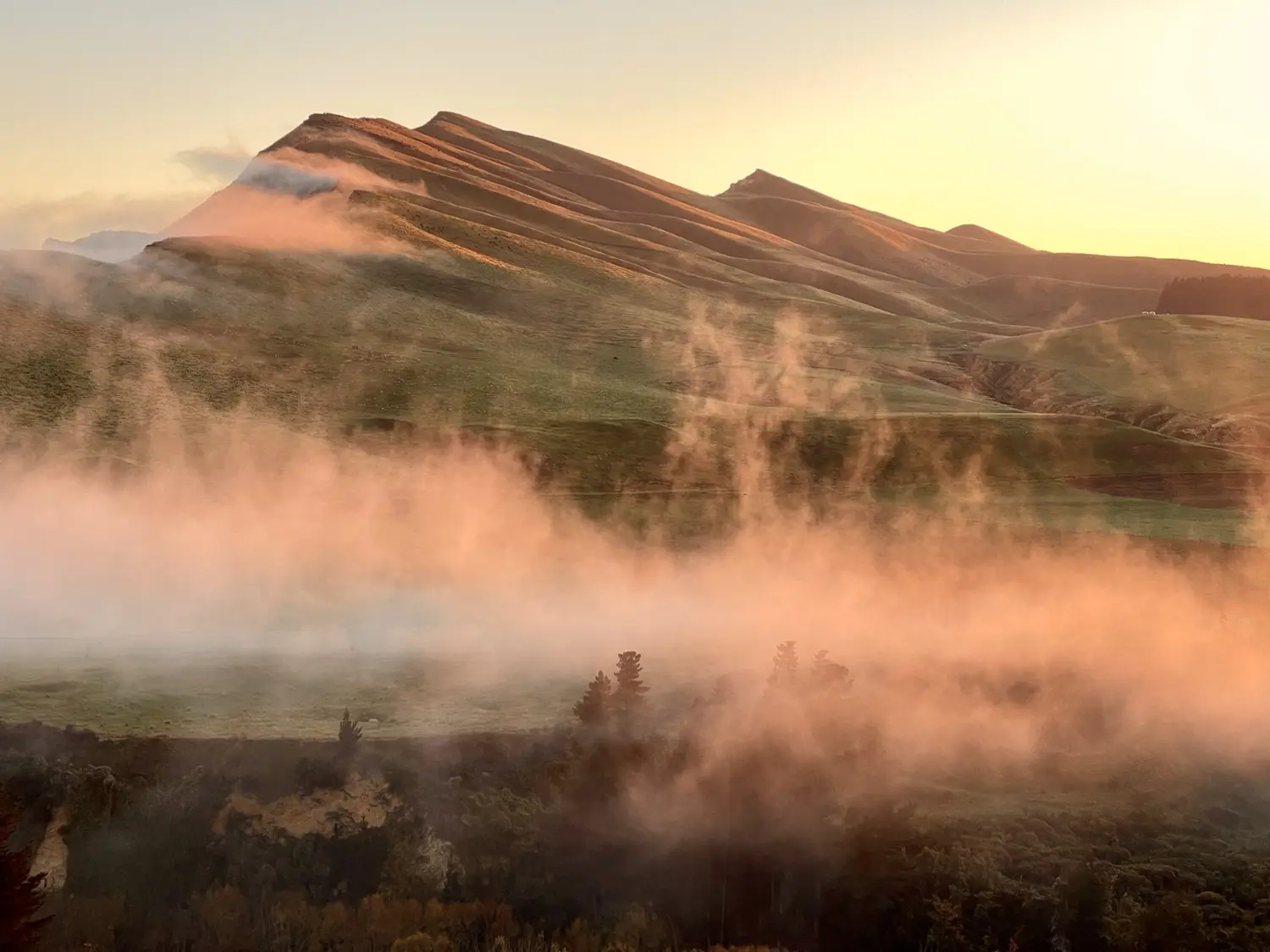 Golden dawn light and mist lifting off high-country hills